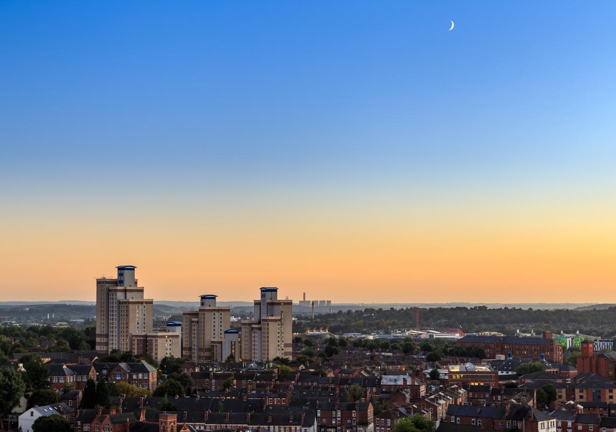 Radford and the Nottingham skyline at dusk, with the tower blocks and red-brick terraces lit by the setting sun